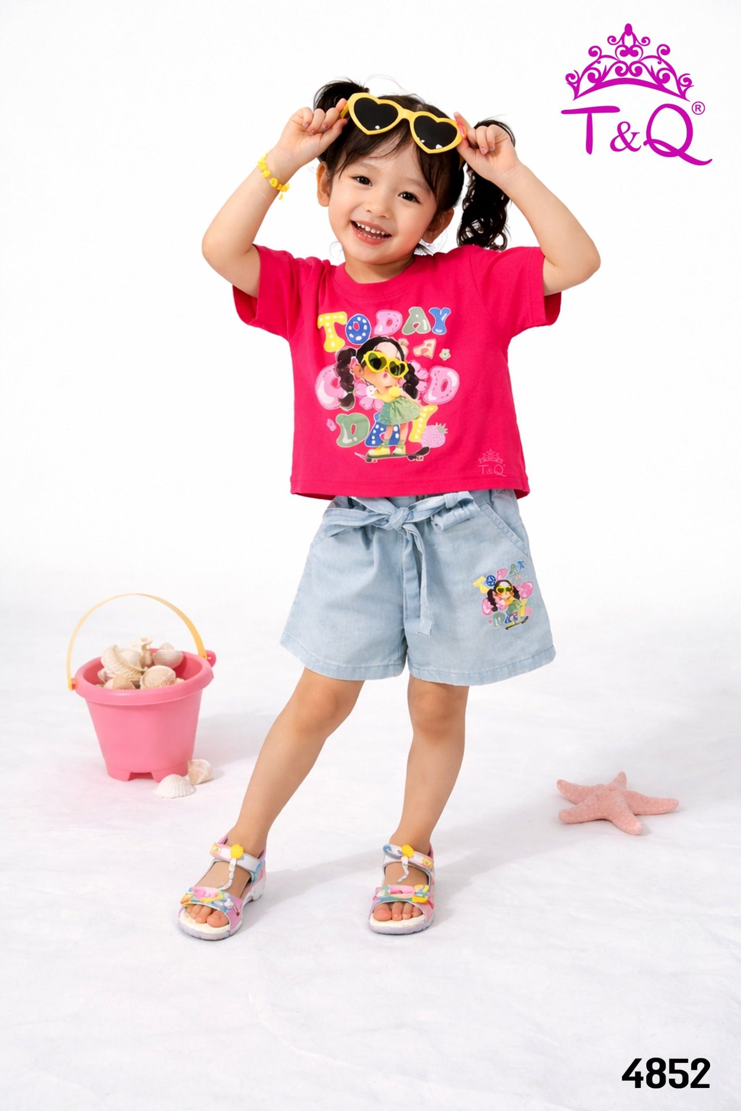 Girl in a rani pink graphic tee and denim shorts set by T and Q