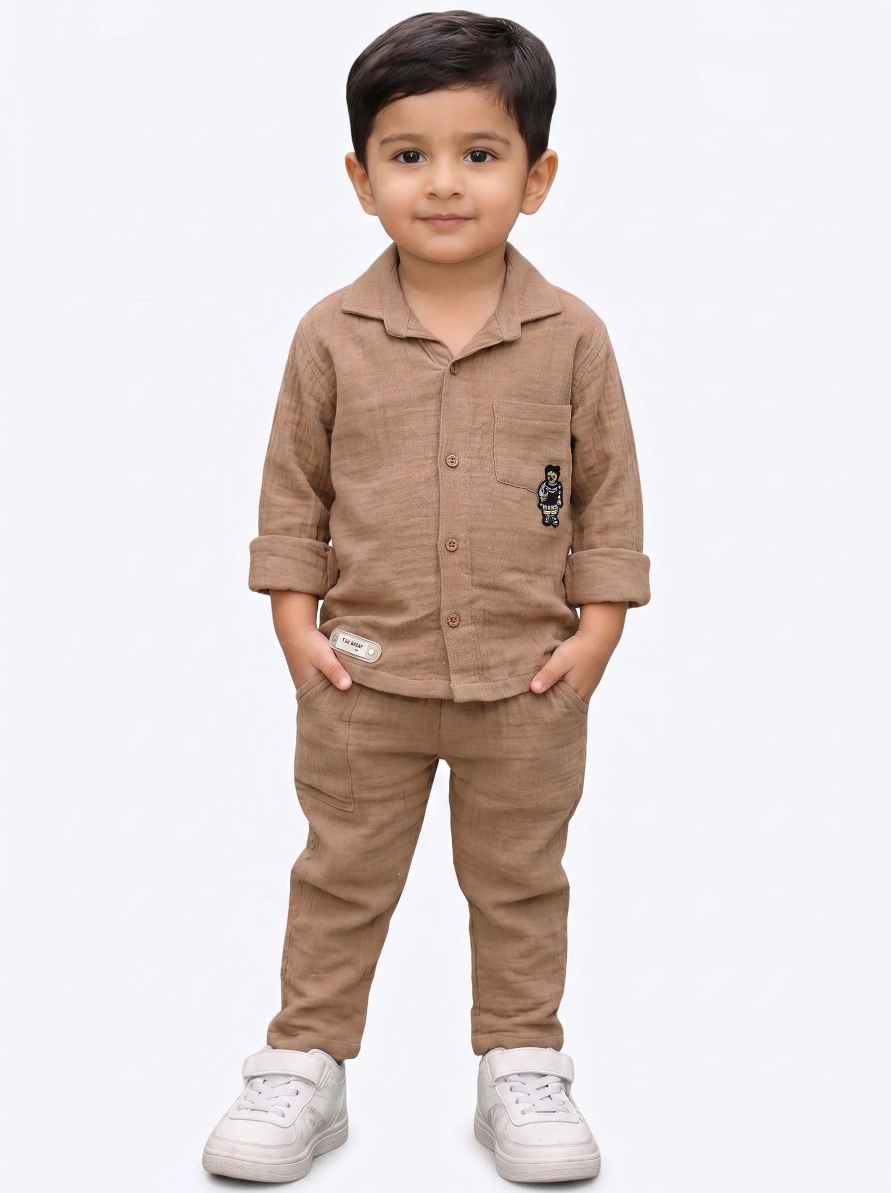 Boy in a biscuit solid muslin shirt and matching trouser co-ord set by Boyz Fun