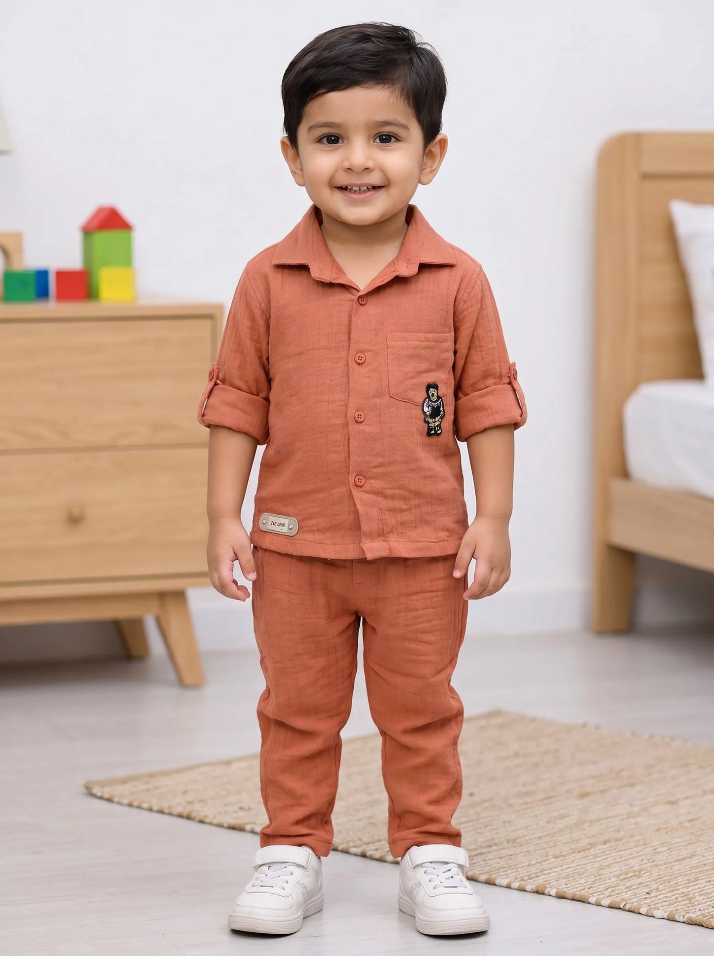 Boy in an orange solid muslin shirt and matching trouser co-ord set by Boyz Fun