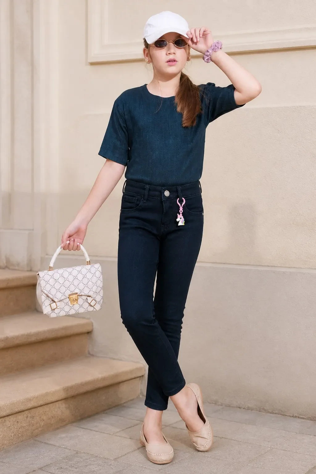 Girl in blue charm-detail ankle skinny jeans with a navy top, Gilly Billy