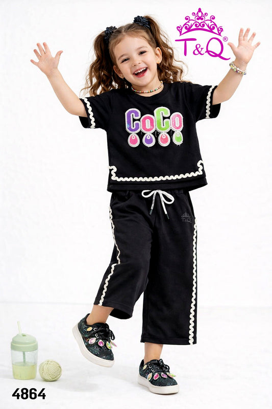 Girl in a black sequin top and matching side-stripe trousers by T and Q