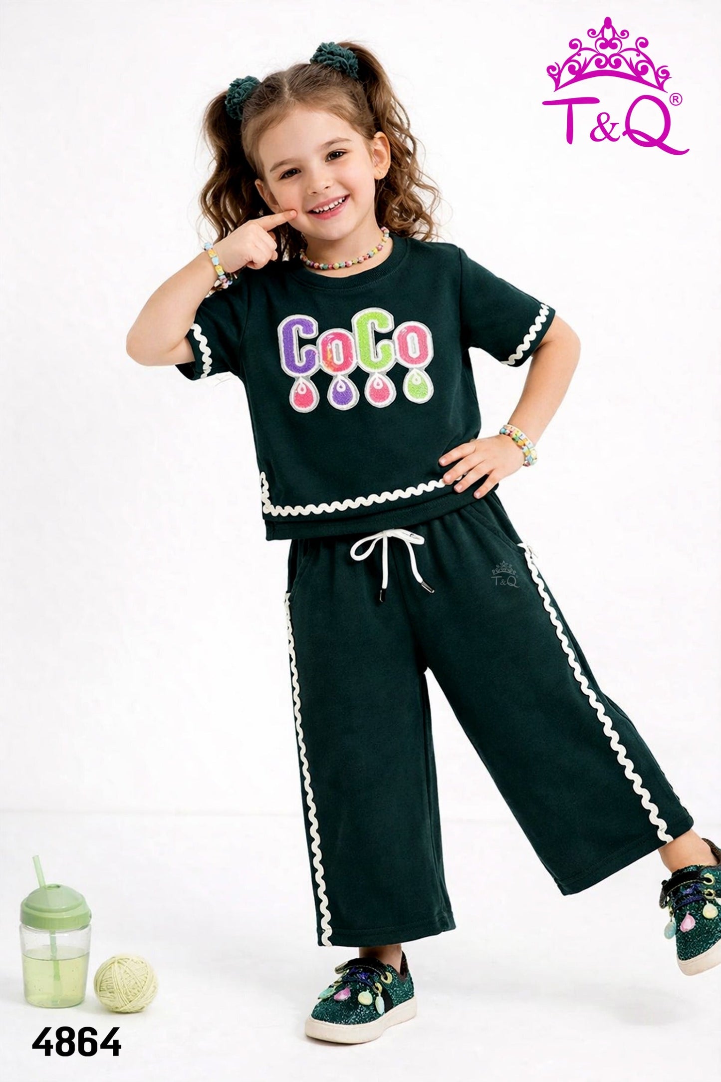 Girl in a dark green sequin top and matching trousers set by T and Q