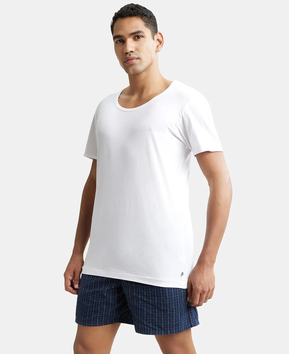 Side view of a model in a Jockey men's white half sleeve cotton vest