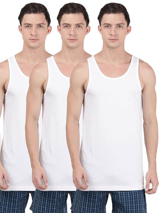 Three models wearing Jockey men's white sleeveless cotton vests, 3-pack