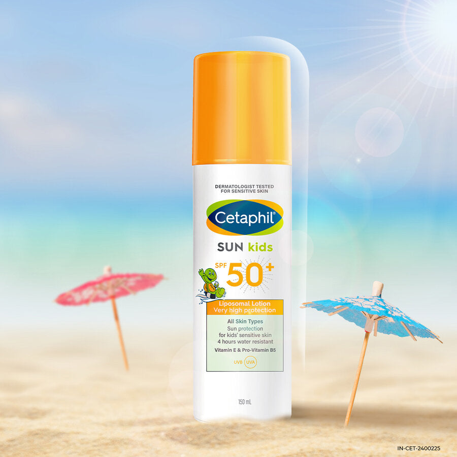 Cetaphil Sun Kids SPF 50 plus lotion bottle on a beach with a parasol