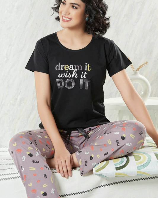 Woman in a black Dream It slogan tee and grey printed pyjama, In Touche night suit