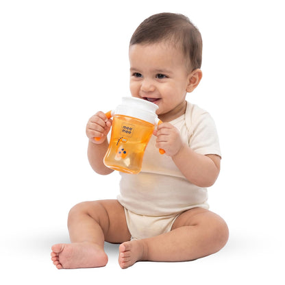 Baby holding an orange Mee Mee 360 degree trainer sippy cup