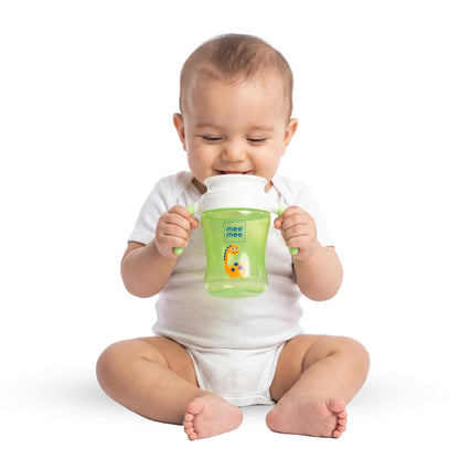 Baby holding a green Mee Mee trainer sippy cup with both hands