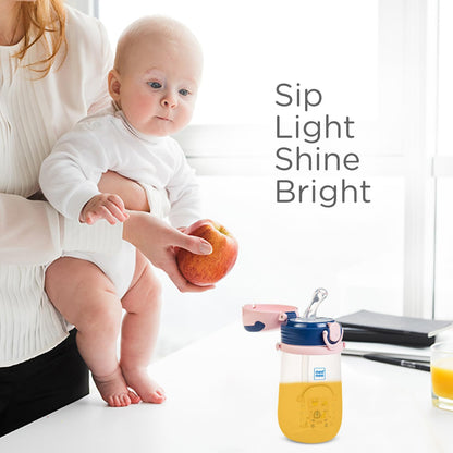 Baby holding a Mee Mee easy-grip sipper cup, sip light shine bright