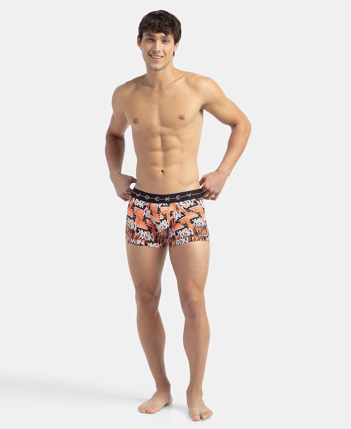 Full-length view of a model wearing Jockey orange printed stretch trunks