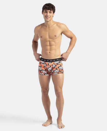 Full-length view of a model wearing Jockey orange printed stretch trunks