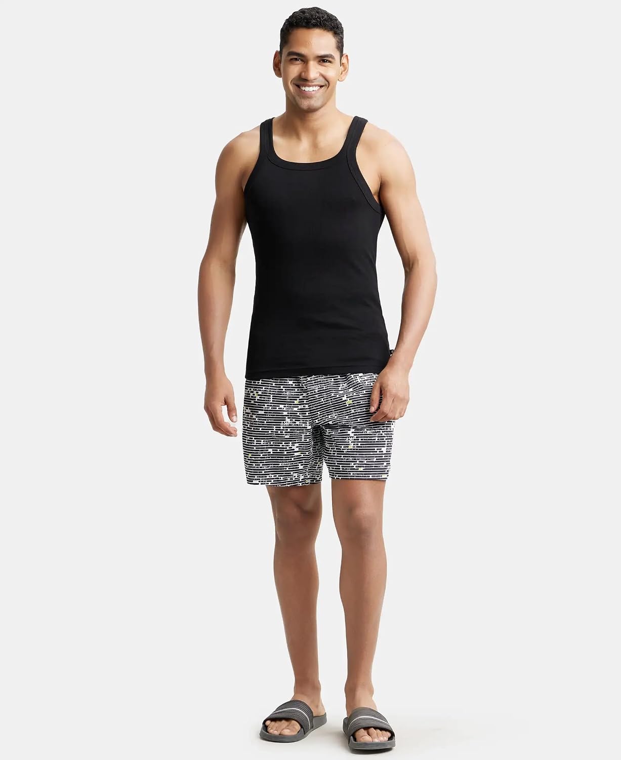 Full-length view of a model in a Jockey US26 black vest and printed shorts